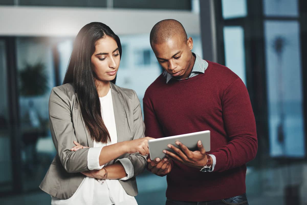 A man and woman looking at a tablet computer